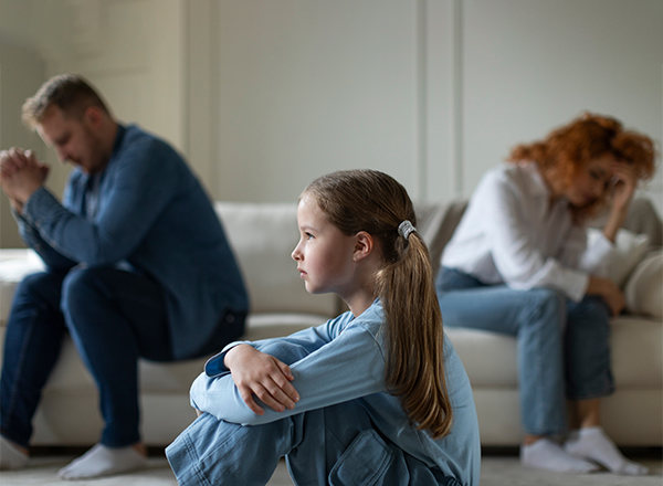 A young person sitting alone, feeling the weight of unspoken tension at home